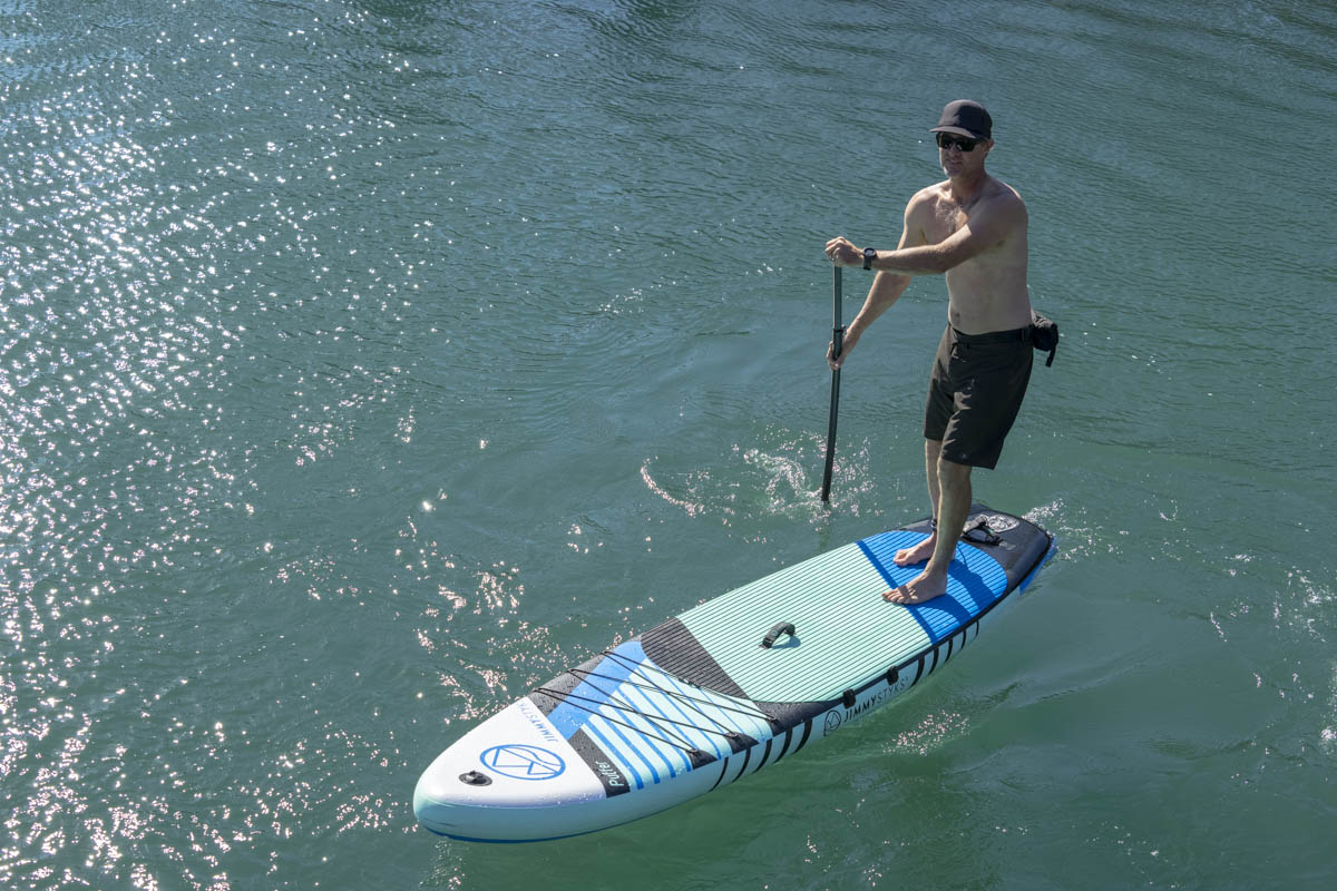 A man is paddle boarding with Jimmy Styks inflatable SUPs
