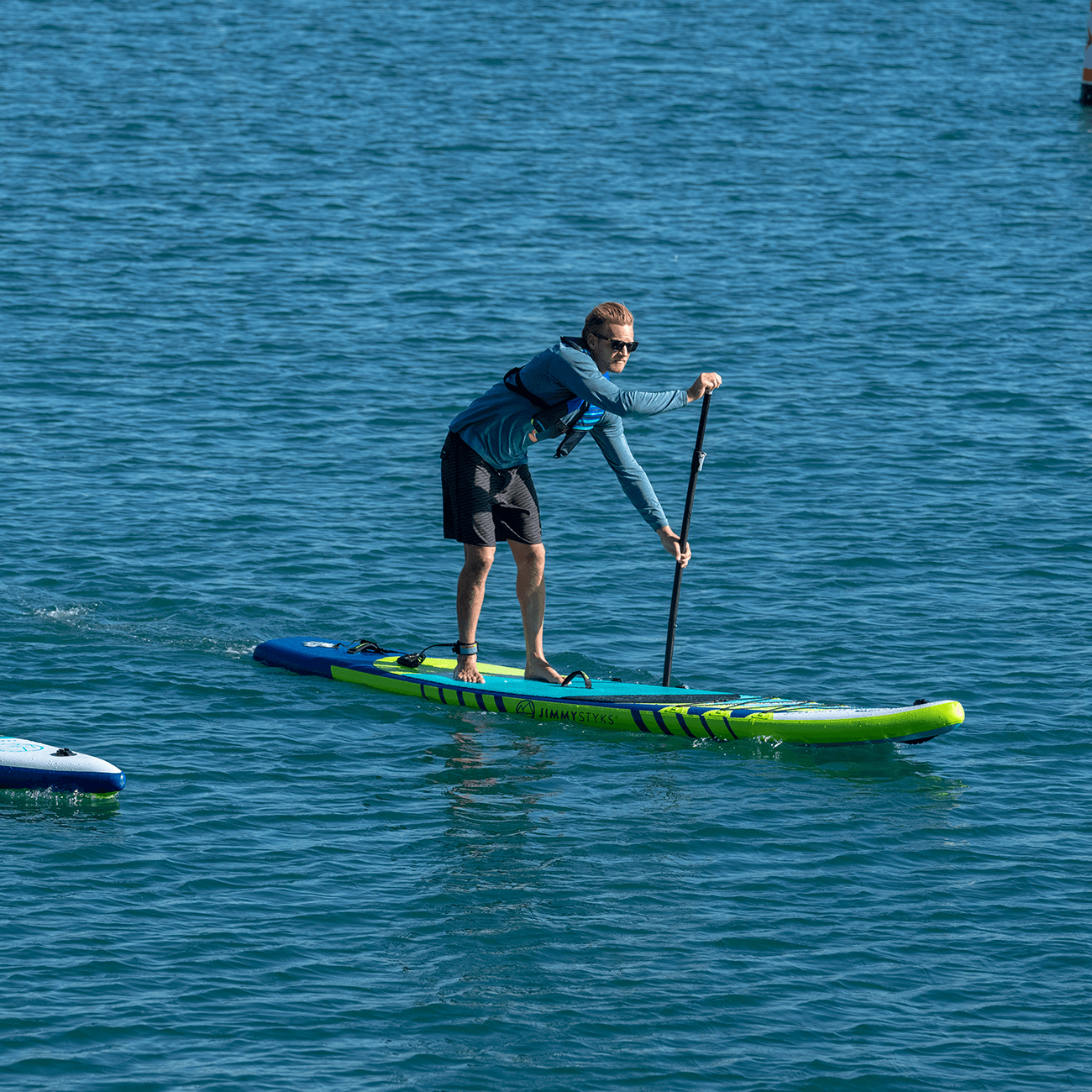 A man is paddling with Jimmy Styks ISUP