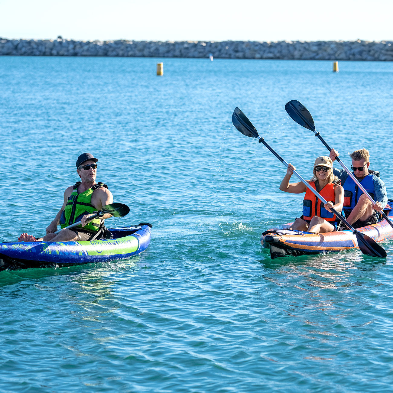 a man and a pair of couple is paddling with inflatable kayak