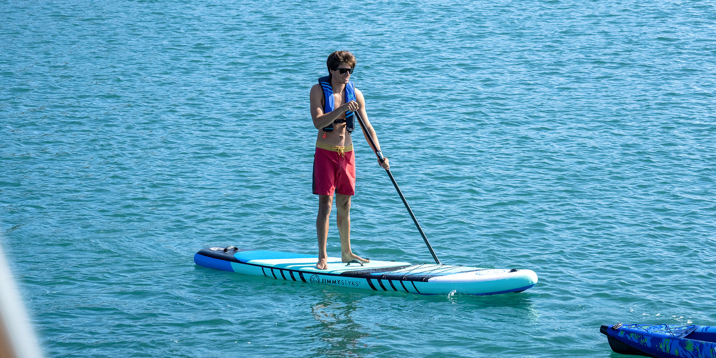 A man is paddling with inflatable stand up paddle board