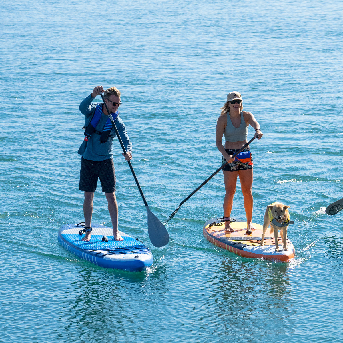 A man and a woman is paddling on the water with Jimmy Styks Inflatable Stand Up Paddle Board